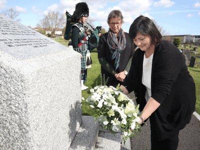 Vice Chair of the Board Catherine Champion with invited guest Nikki Spence placing a wreath on the mass blitz grave at Belfast City Cemetery.