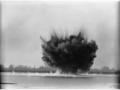 A mine that has been washed up explodes in a welter of mud and water, detonated by the Royal Navy Bomb Disposal Team (location unknown) - IWM A 2013